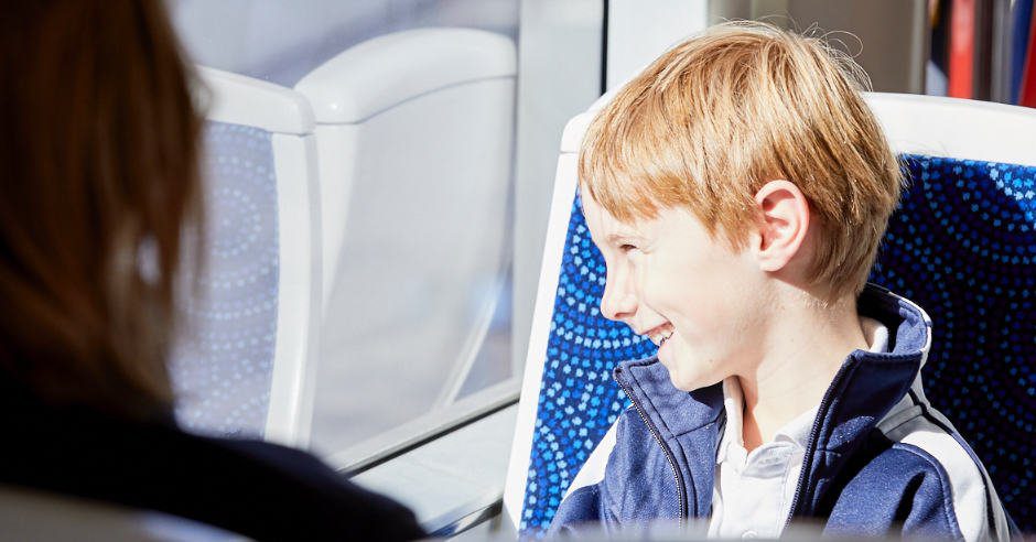 Child riding Canberra Metro light rail vehicle looking out window
